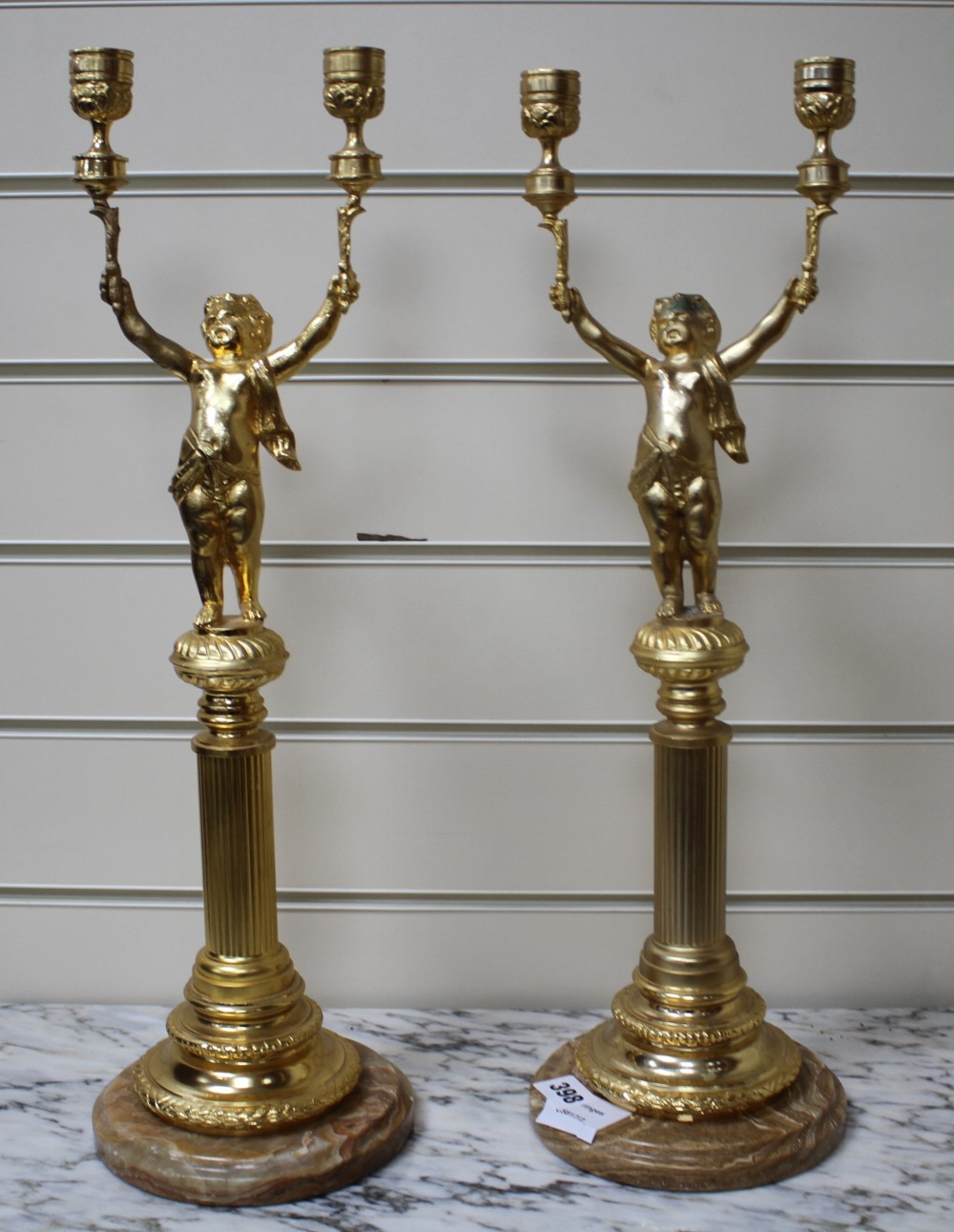 A pair of Italian gilt metal candelabra, with putto stems and marble bases, height 51cm